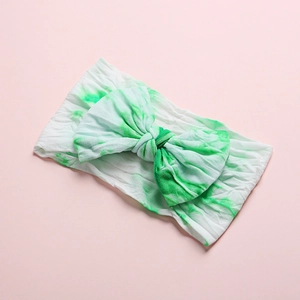 Detail of baby headband featuring green tie-dye pattern on high-elastic bow fabric