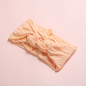 Bandeau à pois pour bébés avec nœud torsadé en nylon souple de couleur pêche