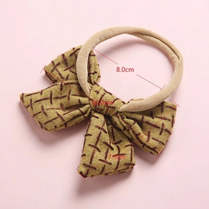 Baby bow headband in linen style with red plaid pattern and nude elastic nylon band