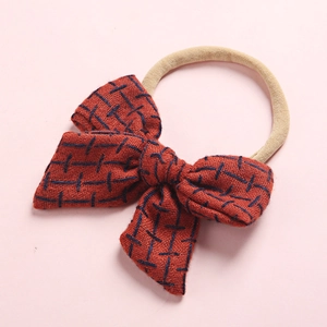 Detail view of red plaid linen bow baby headband with soft high elastic nylon band