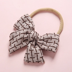 Linen bow baby headband with brown dashed pattern on a soft nylon elastic band
