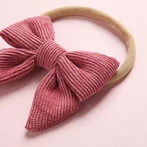 Pink corduroy bow headband with a soft stretch nylon band for baby girls