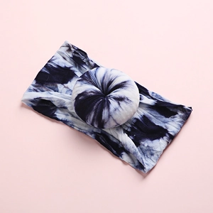 Close-up of bohemian tie-dye baby nylon headband with donut knot on pink background