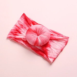 Detail of pink tie-dye baby headband featuring a soft donut-shaped knot and nylon fabric
