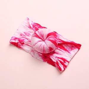 Detail of pink tie-dye baby nylon headband featuring a soft donut-shaped knot design