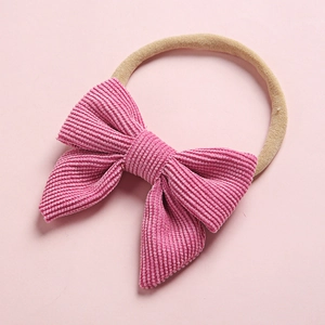 Close-up of pink corduroy bow hairband with soft high-elastic nylon band for babies