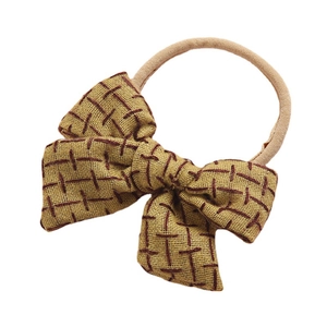 Linen bow headband for baby in yellow-brown with red cross-stitch and soft nude elastic band