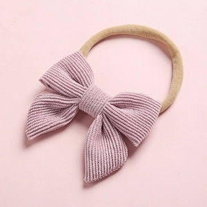 Detailed close-up of pink corduroy bow headband with soft stretch nylon band for infants