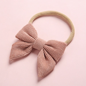 Detail of pink corduroy bow texture and soft elastic nylon baby headband