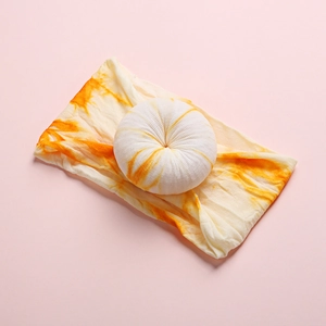 Detail of baby tie-dye nylon headband with a 3D stitched donut knot on pink background