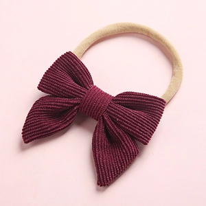 Detailed view of dark red corduroy bow with highly elastic soft nylon baby headband