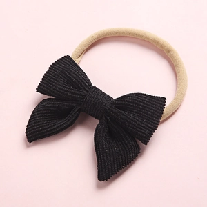 Detail of black corduroy bow on soft nylon headband for children and infants