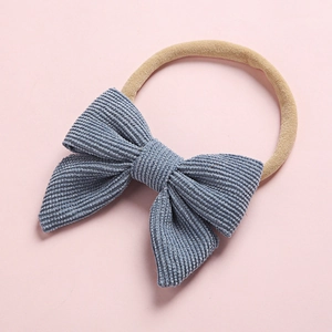 Detailed view of baby headband with a blue corduroy bow on a soft nylon elastic band
