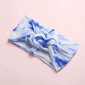 Detail of blue and white tie-dye braided baby headband with soft knitted texture