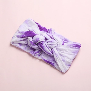 Detail of soft tie-dye baby headband with central knot design and stretchy knit texture
