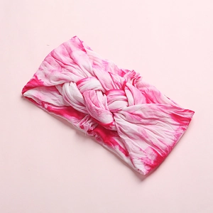 Detail view of pink tie-dye knot headband made of soft and elastic knitted fabric