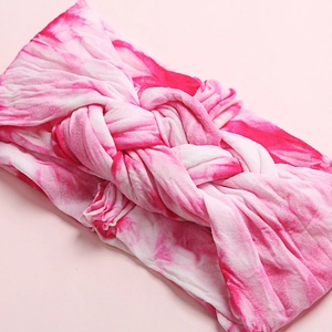 Pink and white tie-dye baby headband featuring a soft braided twist knot design