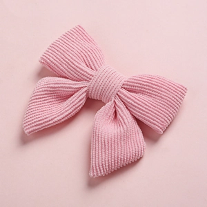 Détail de la texture du tissu en velours côtelé rose doux des nœuds pour cheveux