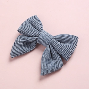 Détail d'une barrette à cheveux nœud en velours côtelé bleu-gris avec texture nervurée
