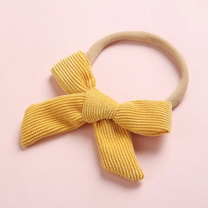 Détail du nœud en velours côtelé jaune et bandeau en nylon pour bébés et enfants