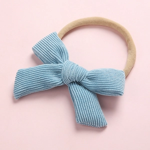Détail du nœud en velours côtelé bleu ciel sur bandeau élastique pour bébé