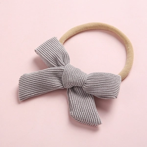 Détail du bandeau pour bébé avec nœud en velours côtelé gris et élastique en nylon doux