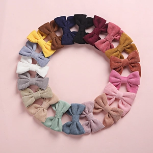 Lot de 18 barrettes à nœud en velours côtelé pour filles disposées en cercle sur fond rose
