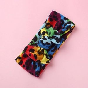 Dettaglio fascia per neonati con stampa leopardata arcobaleno e fiocco in maglia