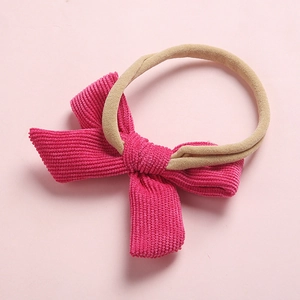 Gros plan détaillé sur un nœud en velours côtelé rose et bandeau bébé en nylon souple