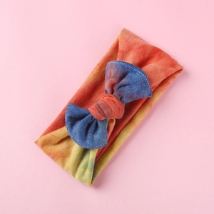 Vista dettagliata della fascia per neonati in maglia tie-dye con un grazioso fiocco morbido