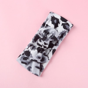 Dettaglio fascia per neonati con fiocco leopardato nero e grigio su maglia elastica