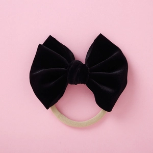 Detail einer weichen 5-Zoll Samtschleife in Schwarz mit beige elastischem Nylon-Stirnband