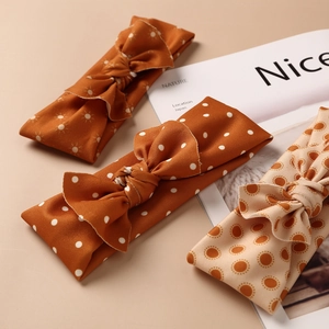 Three-pack vintage elastic baby headbands with orange bow patterns and soft fabric