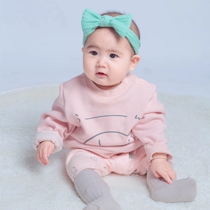 Détail du bandeau nœud vert menthe assorti à l'ensemble pull et pantalon rose pour bébé