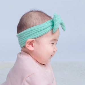 Bandeau bébé avec nœud en maille gaufrée vert menthe porté par un nourrisson