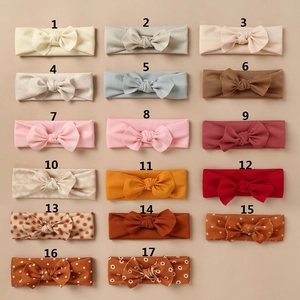 Flat lay detail showing 17 assorted baby bow headbands with floral and rainbow patterns