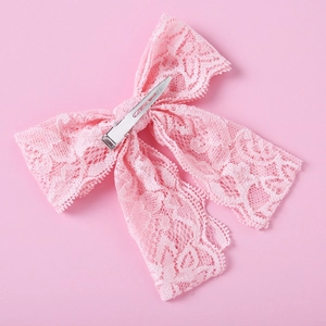 Detailansicht der rosa Spitzen-Haarschleife mit Textur und silbernem Metall-Krokodilclip