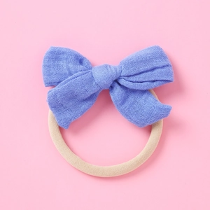 Détail d'un nœud en coton bleu sur un bandeau en nylon doux pour bébés et nourrissons