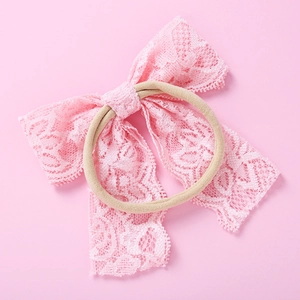 Gros plan sur un bandeau en dentelle rose pour bébé avec texture de maille fleurie