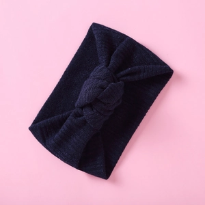 Detail der marineblauen Strickstruktur und des dekorativen Knotens am Baby-Stirnband