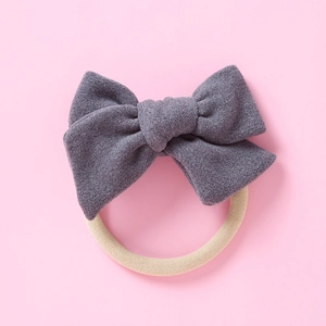 Vue détaillée d'un bandeau à nœud en velours gris avec une bande en nylon doux pour bébés