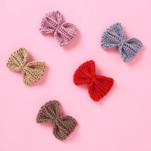 Set of 5 knitted yarn bow clips in assorted colors on a soft pink background