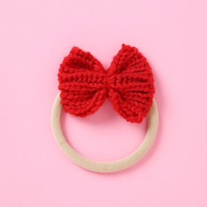 Detailed macro view of red knitted bow with high elastic seamless beige hair tie