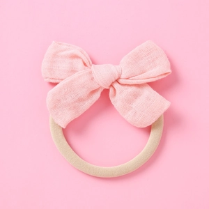 Détail du bandeau avec nœud en lin rose et bande en nylon élastique sans couture