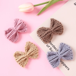 Set of four knitted bow hair clips in pink, brown, tan, and blue for girls' styling