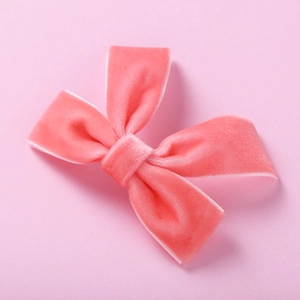Détail du nœud papillon en velours rose vif pour bébés avec une texture douce