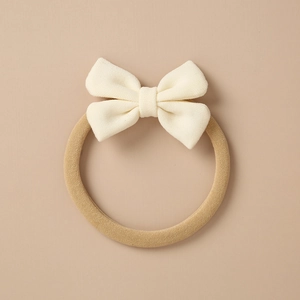 Detail of high-elasticity nylon baby headband with cream-colored waffle fabric bow tie
