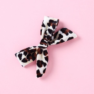 Detailed top view of leopard print velvet bow hair clip for girls on pink background