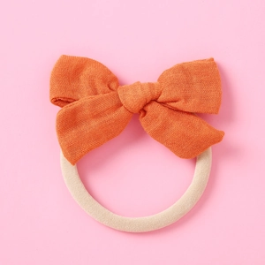 Détail du nœud en lin orange avec un bandeau en nylon blanc cassé haute élasticité