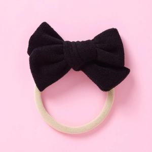 Détail d'un bandeau à nœud en velours noir avec un élastique en nylon beige doux